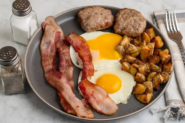  Domuz pastırmalı sahanda yumurta ve patates kızartmasıyla servis edilen sosisli börek.