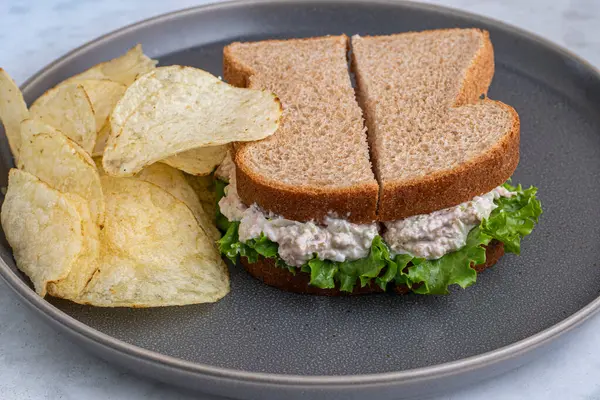 Patates cipsiyle servis edilen buğday ekmekli marullu tavuk salatası.