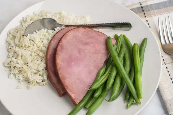  İki dilim jambon ve pirinçli yeşil fasulye.