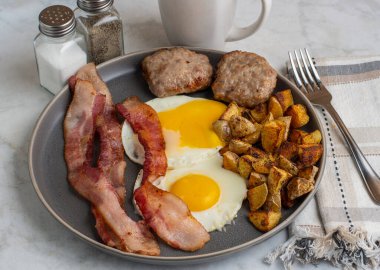  Domuz pastırmalı sahanda yumurta ve patates kızartmasıyla servis edilen sosisli börek.