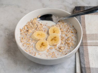 yulaf ezmesi ve muzla servis edilen süt.