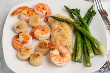 kuşkonmaz, istiridye ve karides ile servis edilen mezgit.