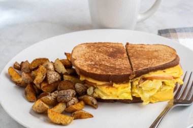 Çırpılmış yumurta ve Kanada pastırmalı peynirli sandviç erimiş kahvaltı sandviçi.
