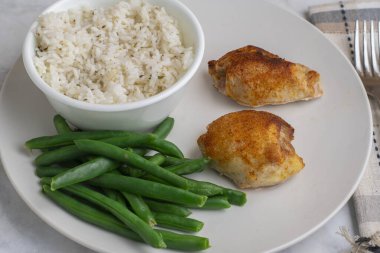 Pirinç ve yeşil fasulyeyle servis edilen tavuk butları.