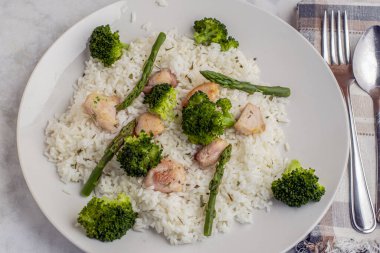 pirinç ve chiocken kuşkonmaz, brokoli ve maydanozla servis edilir..