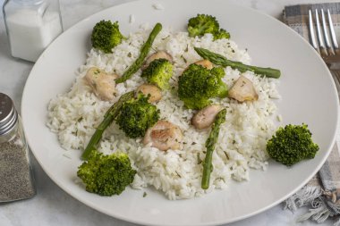 pirinç ve chiocken kuşkonmaz, brokoli ve maydanozla servis edilir..