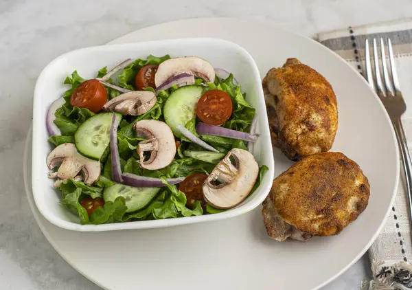 Kırmızı biberli tavuk budu, sarımsaklı tuz ve bahçe salatasıyla servis edilen soğan tuzu.