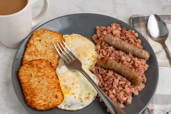 Kahvaltıda sosis ve mücver ile servis edilen mısır biftekli yumurta.