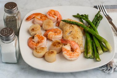 kuşkonmaz, istiridye ve karides ile servis edilen mezgit.