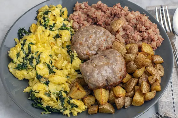 Çırpılmış yumurta, sosisli börek, patates kızartması ve mısır gevreği ile servis edilir.