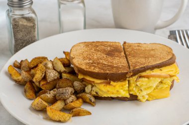 Çırpılmış yumurta ve Kanada pastırmalı peynirli sandviç erimiş kahvaltı sandviçi.