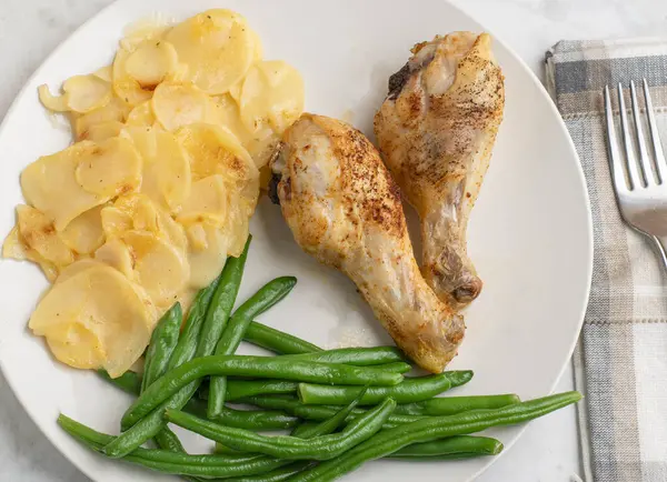 Tavuk budu patates ve yeşil fasulyeyle servis edilir., 