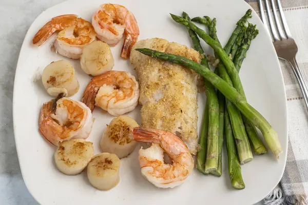 kuşkonmaz, istiridye ve karides ile servis edilen mezgit.