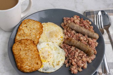 Kahvaltıda sosis ve mücver ile servis edilen mısır biftekli yumurta.