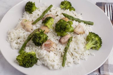 pirinç ve chiocken kuşkonmaz, brokoli ve maydanozla servis edilir..