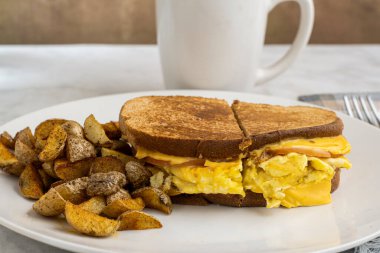 Çırpılmış yumurta ve Kanada pastırmalı peynirli sandviç erimiş kahvaltı sandviçi.