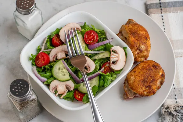 Kırmızı biberli tavuk budu, sarımsaklı tuz ve bahçe salatasıyla servis edilen soğan tuzu.