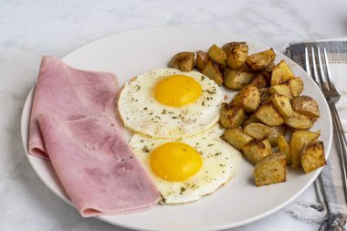 Maydanoz ve biberli sahanda yumurta dilimlenmiş jambon ve patates kızartması.