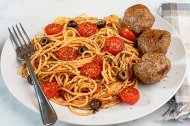  Domatesli spagetti üstü, zeytin ve kısmen İtalyan köfteleriyle servis edilir.