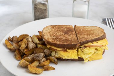 Çırpılmış yumurta ve Kanada pastırmalı peynirli sandviç erimiş kahvaltı sandviçi.