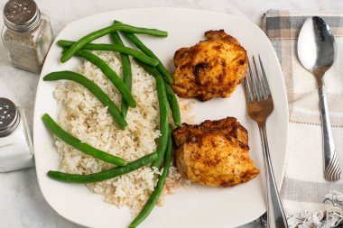  Pirinç ve yeşil fasulyeyle servis edilen tavuk butları.