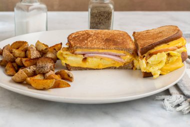 Çırpılmış yumurta ve Kanada pastırmalı peynirli sandviç erimiş kahvaltı sandviçi.