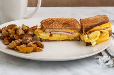 Çırpılmış yumurta ve Kanada pastırmalı peynirli sandviç erimiş kahvaltı sandviçi.