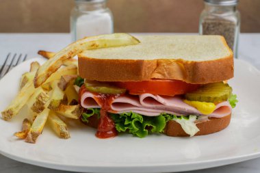 marullu jambonlu sandviç, domates ve patates kızartması.