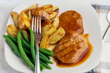  Yeşil fasulyeli salisbury bifteği ve soslu patates dilimleri.