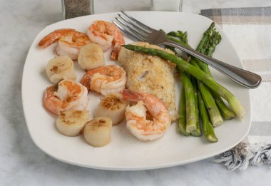 kuşkonmaz, istiridye ve karides ile servis edilen mezgit.