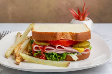 marullu jambonlu sandviç, domates ve patates kızartması.