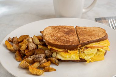Çırpılmış yumurta ve Kanada pastırmalı peynirli sandviç erimiş kahvaltı sandviçi.