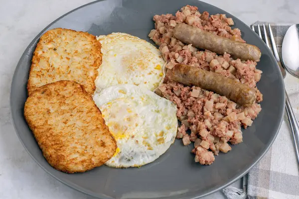 Kahvaltıda sosis ve mücver ile servis edilen mısır biftekli yumurta.