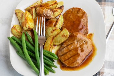  Yeşil fasulyeli salisbury bifteği ve soslu patates dilimleri.