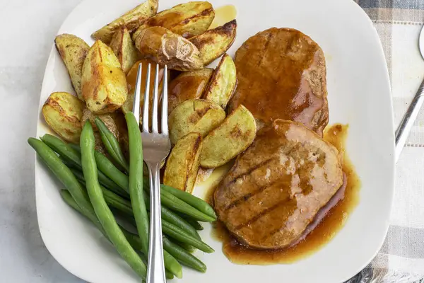  Yeşil fasulyeli salisbury bifteği ve soslu patates dilimleri.