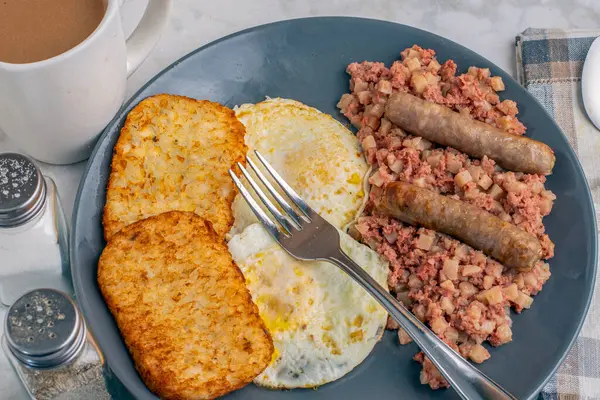 Kahvaltıda sosis ve mücver ile servis edilen mısır biftekli yumurta.