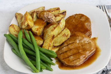  Yeşil fasulyeli salisbury bifteği ve soslu patates dilimleri.