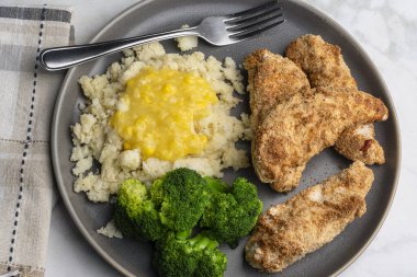 Patates püresiyle servis edilen tavuk kanatları kremalı mısır ve brokoli ile servis ediliyor.,