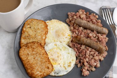 Kahvaltıda sosis ve mücver ile servis edilen mısır biftekli yumurta.