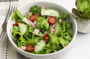  Doğranmış jambon, domates, marul ve salatalıklı taze salata.