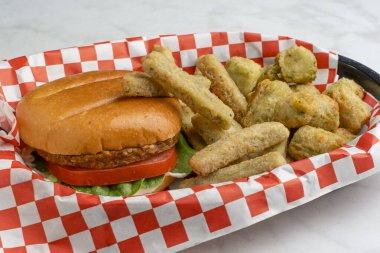 Domatesli sebze bahçesi burgeri ve çörekli ıspanak. Sebze ve patates kızartması ile servis edilir.