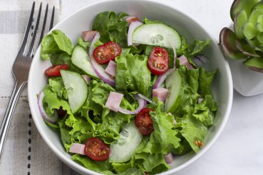  Doğranmış jambon, domates, marul ve salatalıklı taze salata.