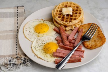 Waffle 'lı sahanda yumurta ve konserve jambonlu patates.