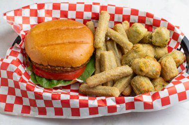 Domatesli sebze bahçesi burgeri ve çörekli ıspanak. Sebze ve patates kızartması ile servis edilir.