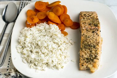 baharatlı somon ve pirinç ve havuçla servis edilen karabiber.