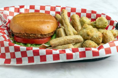 Domatesli sebze bahçesi burgeri ve çörekli ıspanak. Sebze ve patates kızartması ile servis edilir.