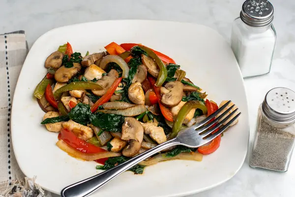 Biber, soğan ve mantarlı sotelenmiş tavuk yemeği., 