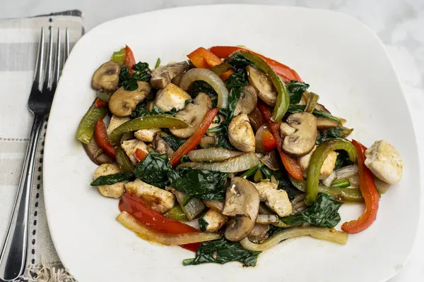 Biber, soğan ve mantarlı sotelenmiş tavuk yemeği., 