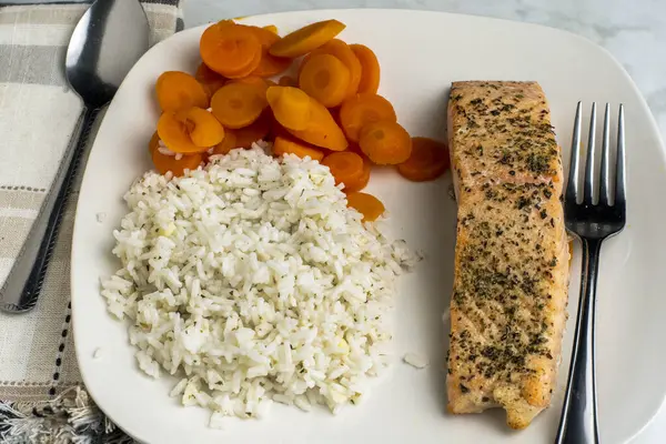 baharatlı somon ve pirinç ve havuçla servis edilen karabiber.