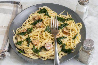  Sotelenmiş ıspanakla servis edilen sosisli tavuk.